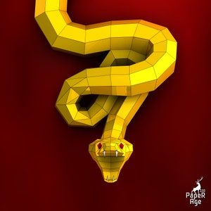 May include: A yellow papercraft snake with red eyes and fangs. The snake is curled up in a coil with its head facing forward. The background is a solid red color.