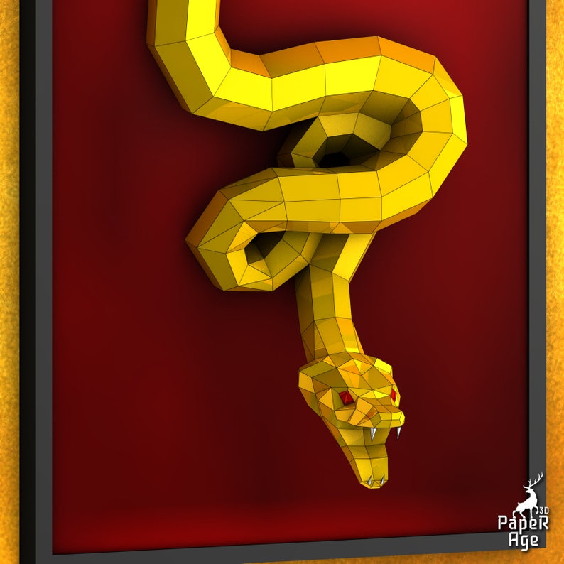 May include: A golden papercraft snake with red eyes, hanging on a red background. The snake is curled up in a coil with its head facing forward. The snake is made of paper and has a 3D effect.