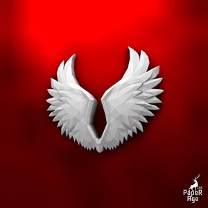 Puede incluir: Alas de papel blanco con un dise&ntilde;o geom&eacute;trico, dobladas en forma sim&eacute;trica. Las alas est&aacute;n sobre un fondo rojo.