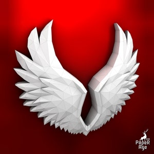 Puede incluir: Alas blancas de papel en un dise&ntilde;o sim&eacute;trico plegado. Las alas est&aacute;n hechas de tri&aacute;ngulos y est&aacute;n dispuestas de forma que se asemejan a las alas de un p&aacute;jaro. Las alas est&aacute;n sobre un fondo rojo.