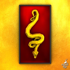 Könnte beinhalten: Eine gelbe Papierschlangen-Skulptur in einem roten Rahmen. Die Schlange ist zusammengerollt, mit dem Kopf nach unten. Der Rahmen ist schwarz und hat einen weißen Rand.