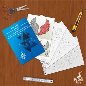 Puede incluir: Un conjunto de instrucciones de papercraft para construir un modelo 3D de un par de alas. Las instrucciones est&aacute;n impresas en papel blanco e incluyen una breve gu&iacute;a con el texto "Short guide" y "You are welcome to the World of 30 polygonal models! This short guide will help you to materialize a paper 3D model created by Paper Age 3D models company".