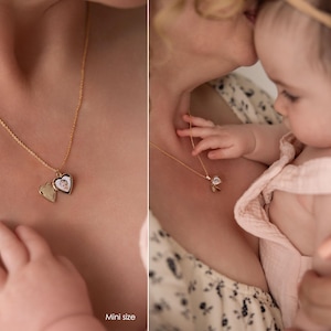 May include: A woman wearing a floral dress holds a baby wearing a pink dress. The woman is wearing a gold necklace with a heart-shaped locket. The locket has a picture inside. The text "Mini size" is visible in the bottom right corner of the image.