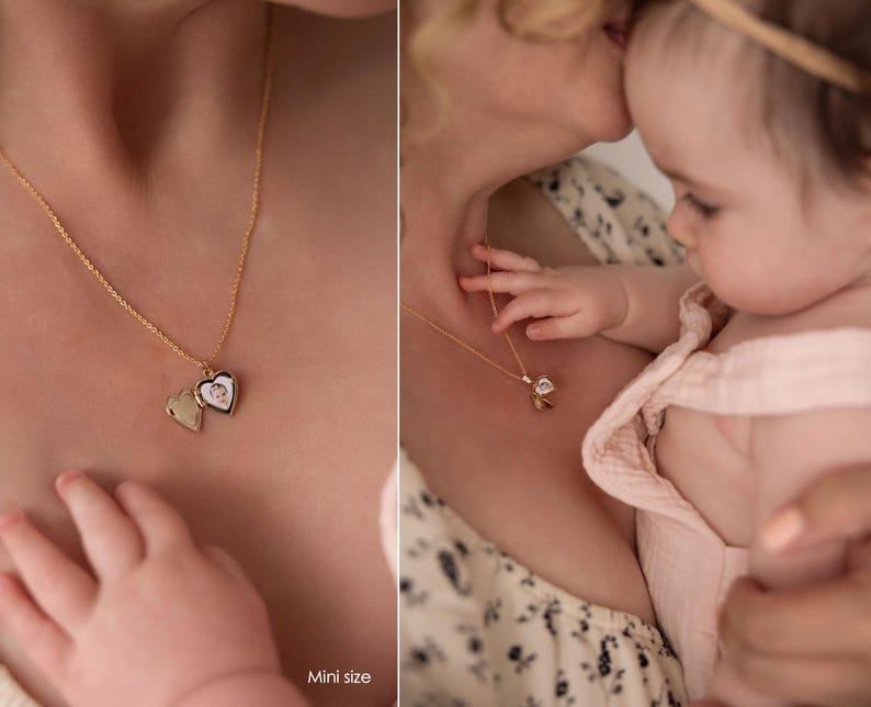 May include: A woman wearing a floral dress holds a baby wearing a pink dress. The woman is wearing a gold necklace with a heart-shaped locket. The locket has a picture inside. The text "Mini size" is visible in the bottom right corner of the image.