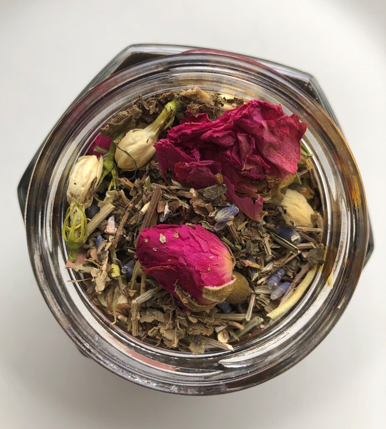May include: A glass jar filled with dried herbs, rose petals, and lavender buds. The jar is clear and has a lid.
