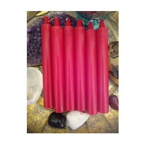 May include: Six red taper candles arranged in a row on a gold surface. The candles are approximately 7 inches long and have a smooth, even texture.