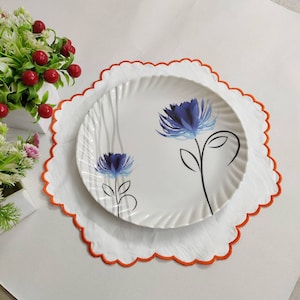 White linen round table mats with scallop edges in orange for table decor