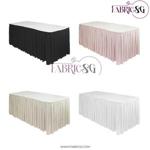 Könnte beinhalten: Vier rechteckige Tische mit plissierten Röcken in Schwarz, Rosa, Beige und Weiß. Jeder Tisch hat eine weiße Oberseite und einen Rock, der bis zum Boden reicht. Die Tische sind vor einem weißen Hintergrund angeordnet. Das Fabric SG-Logo befindet sich oben rechts.