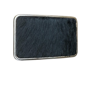 Belt buckle with black hair on lether