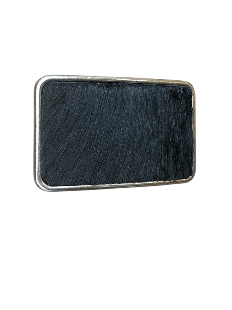 Belt buckle with black hair on lether