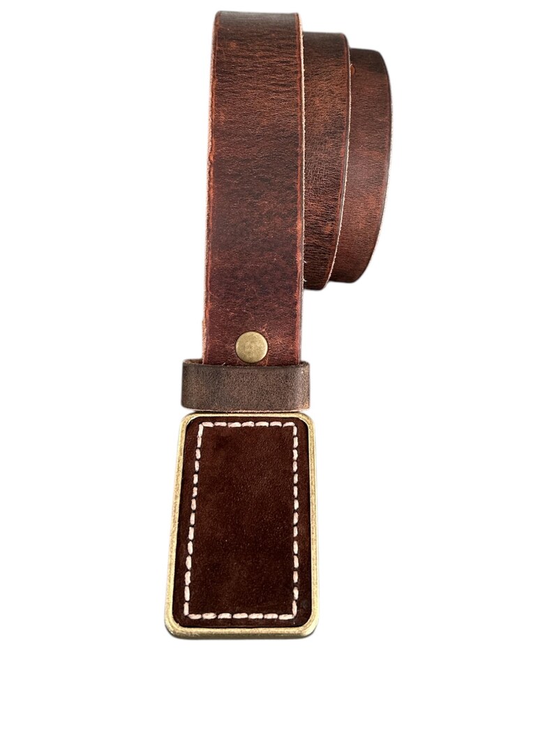 May include: A brown leather belt with a brass buckle. The buckle has a brown leather insert with white stitching around the edges.