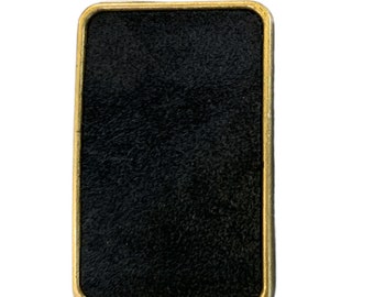 Könnte beinhalten: Eine schwarze rechteckige Plakette mit goldfarbenem Rand. Die Plakette hat eine strukturierte Oberfläche.