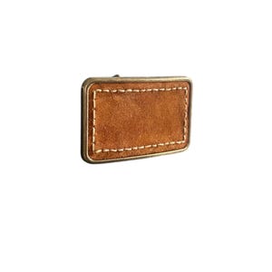May include: A brown leather belt buckle with a stitched border. The buckle is made of metal and has a rectangular shape.