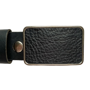 May include: A black leather belt with a silver buckle. The buckle is rectangular and has a smooth, textured surface.