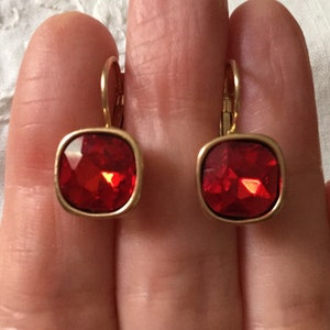 Peut inclure: Une paire de boucles d'oreilles en or avec des pierres de cristal carrées rouges.