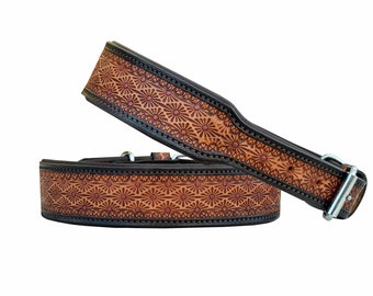 May include: Two brown leather belts with a floral pattern and a silver buckle. The belts are stacked on top of each other.