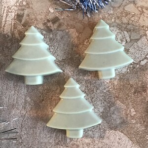 May include: Three light green ceramic Christmas tree decorations. The decorations are shaped like a traditional Christmas tree with a star on top.