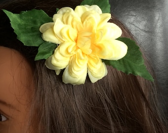 May include: A yellow fabric flower with green leaves, perfect for adding a touch of color to hair.