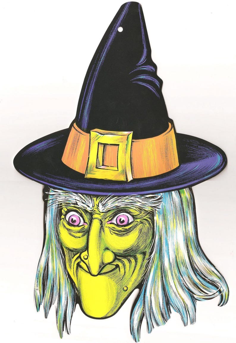 May include: A witch's face with a green face, white hair, and pink eyes. She is wearing a black witch's hat with an orange band and a gold buckle. The hat has a purple brim.