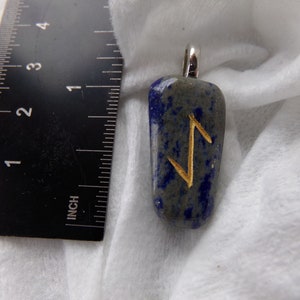 May include: A blue and gray stone pendant with a silver bail. The pendant features a gold-colored rune symbol. The pendant is approximately 1.5 inches long.