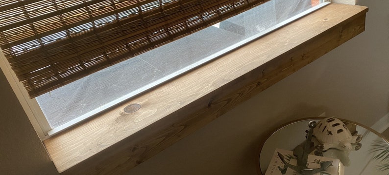 Puede incluir: Primer plano de un alf&eacute;izar de ventana de madera con acabado de madera natural. El alf&eacute;izar de la ventana est&aacute; inclinado y tiene un color marr&oacute;n claro. El alf&eacute;izar de la ventana est&aacute; hecho de una sola pieza de madera.