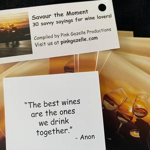 Op de afbeelding: Een set witte kaarten met de tekst Savour the Moment 30 savvy sayings for wine lovers, Compiled by Pink Gazelle Productions, Visit us at pinkgazelle.com, en een kaart met het citaat The best wines are the ones we drink together. - Anon.