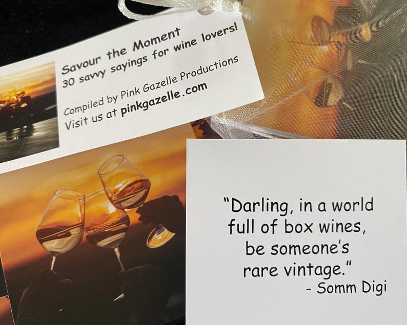 Op de afbeelding: Een set kaarten getiteld Savour the Moment met 30 spreuken voor wijnliefhebbers van Pink Gazelle Productions. E&eacute;n kaart toont een wijntoast bij zonsondergang, terwijl een andere de tekst bevat: Darling, in a world full of box wines, be someone's rare vintage.