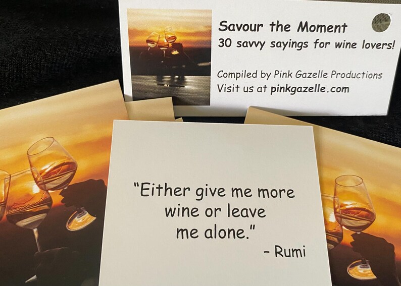 Op de afbeelding: Een set vierkante kaarten met citaten over wijn. E&eacute;n kaart toont de tekst "Either give me more wine or leave me alone." - Rumi. De koptekst op de verpakking luidt "Savour the Moment 30 savvy sayings for wine lovers! Compiled by Pink Gazelle Productions."