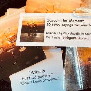 Op de afbeelding: Een set kaarten getiteld Savour the Moment 30 savvy sayings for wine lovers samengesteld door Pink Gazelle Productions. De kaarten bevatten afbeeldingen van wijnglazen bij zonsondergang en citaten zoals Wine is bottled poetry.