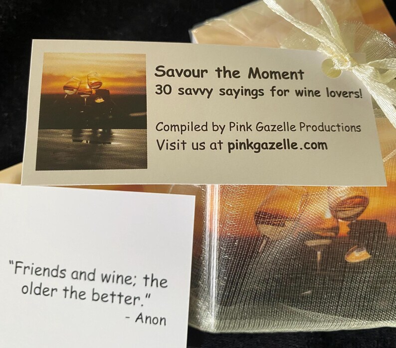Op de afbeelding: Een rechthoekige witte kaart met een zonsondergangafbeelding van wijnglazen en de tekst 'Savour the Moment 30 savvy sayings for wine lovers! Compiled by Pink Gazelle Productions Visit us at pinkgazelle.com' naast een kaart met de tekst 'Friends and wine; the older the better.' - Anon.