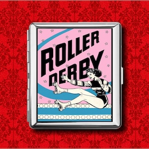 May include: A silver metal cigarette case with a pop art style illustration. The image features a woman in roller skates with the words "ROLLER DERBY" in bold black letters against a pink background with stars and blue stripes.