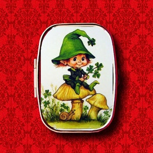 May include: A small, green leprechaun with a green hat sits on a mushroom with a white background. The leprechaun is holding a sprig of shamrocks.