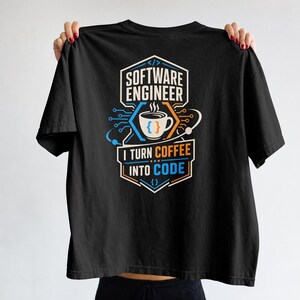 May include: A black t-shirt featuring a graphic design with the text "SOFTWARE ENGINEER" and "I TURN COFFEE INTO CODE". The design includes a coffee cup icon with curly brackets, circuit board lines, and orbital elements in white, blue, and orange.
