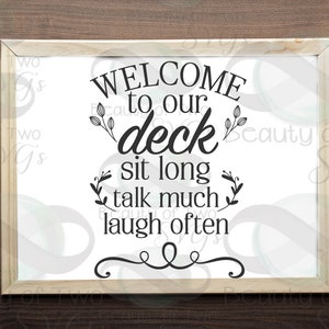 May include: A white framed sign with black text that reads "WELCOME to our deck sit long talk much laugh often". The text is stylized with decorative flourishes.