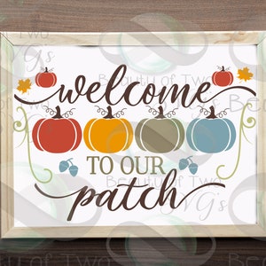 May include: A white sign with the text "Welcome to our patch" in brown cursive lettering. There are five pumpkins in a row, each a different color: red, orange, green, blue, and red. There are also two brown acorns and a single orange leaf.