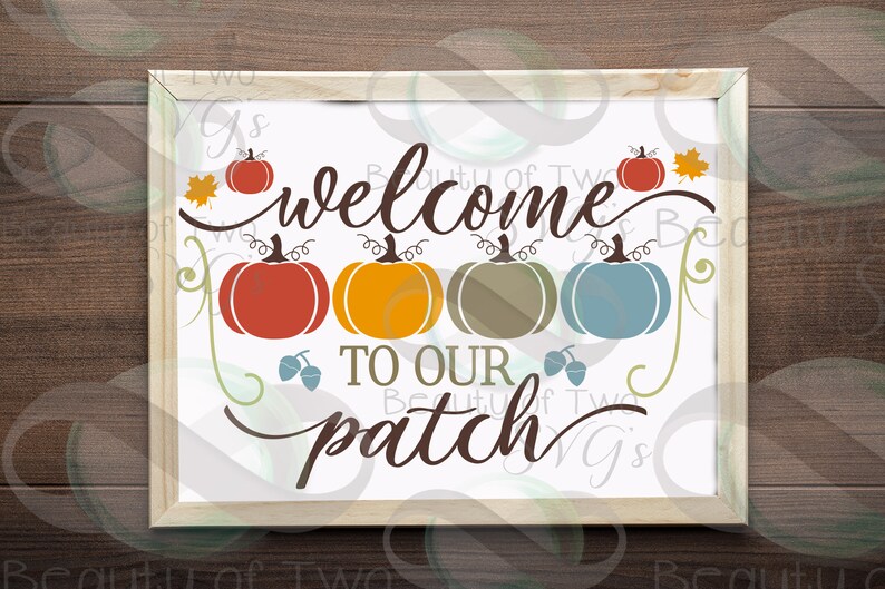 May include: A white sign with the text "Welcome to our patch" in brown cursive lettering. There are five pumpkins in a row, each a different color: red, orange, green, blue, and red. There are also two brown acorns and a single orange leaf.