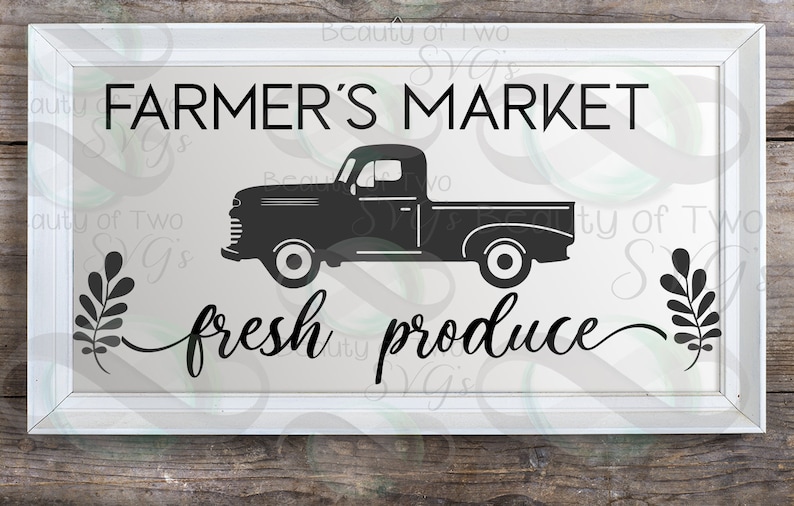 May include: A white framed sign with black text that reads "FARMER'S MARKET" and "fresh produce". A black silhouette of a vintage pickup truck is in the center of the sign.