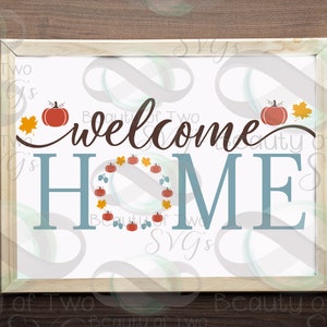 May include: A white sign with the text "welcome home" in brown script. The word "home" is in blue and surrounded by a wreath of orange pumpkins, brown leaves, and green vines.