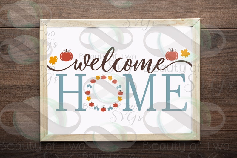 May include: A white sign with the text "welcome home" in brown script. The word "home" is in blue and surrounded by a wreath of orange pumpkins, brown leaves, and green vines.