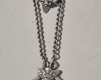 A historic skirt pin made of 835 silver with a Madonna coin and key ring. Traditional dirndl jewelry with angels and Art Nouveau details.