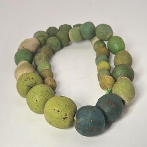 Może przedstawiać: Zestaw trzech ceramicznych kubków z nakrapianym, matowym wykończeniem. Kubki są w odcieniach kremu, jasnoszarym i ciemnoszarym. Każdy kubek ma prosty, minimalistyczny design i zaokrąglony uchwyt.