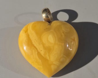 Giant heart pendant made of butterscotch amber with a gold-plated silver eyelet on a rubber cord. 1990s design jewelry. Vintage jewelry. Size 48.