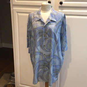 May include: A light blue button-up shirt with a swirling abstract pattern in shades of blue and green.