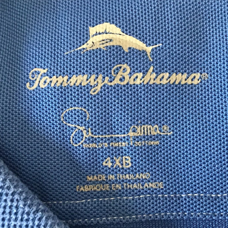 May include: A blue Tommy Bahama polo shirt with a marlin fish logo and the text "Tommy Bahama" and "Pima World's Finest Cotton". The shirt size is 4XB and is made in Thailand.