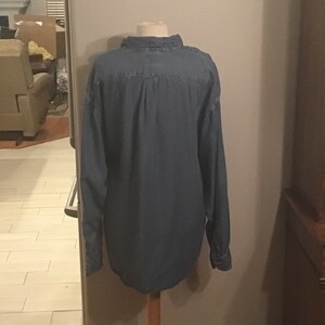 May include: A blue denim long-sleeved shirt with a button-down collar.