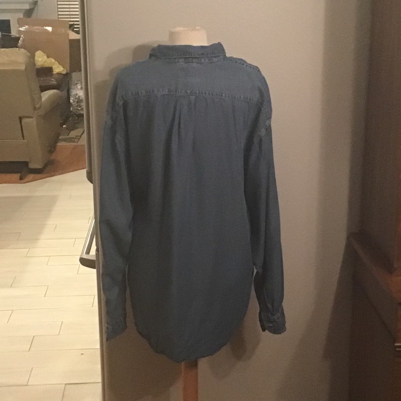 May include: A blue denim long-sleeved shirt with a button-down collar.