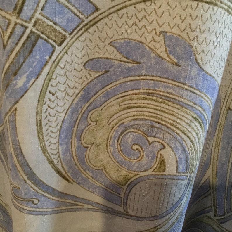 May include: Close-up of a fabric with a blue and brown paisley pattern. The fabric has a textured surface and a slightly faded look.