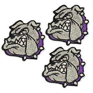 Può includere: Tre toppe ricamate raffiguranti una testa di bulldog con un'espressione feroce. Le toppe hanno una combinazione di colori grigio e bianco con un bordo viola e accenti bianchi. Le toppe sono probabilmente per abbigliamento o accessori.