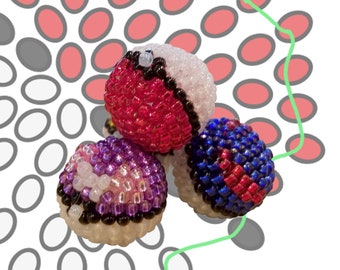 May include: Three Pokeball 2.0 charms made of colorful beads. The charms are red, purple, and blue with white and black accents.
