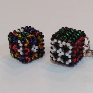 Op de afbeelding: Twee kleine kralenblokjes, een met een kleurrijk patroon en de andere met een zwart-wit-groen patroon. De blokjes zijn gemaakt van kleine kralen en zijn ongeveer 2,5 cm groot.